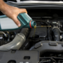A person pouring motor oil into a car